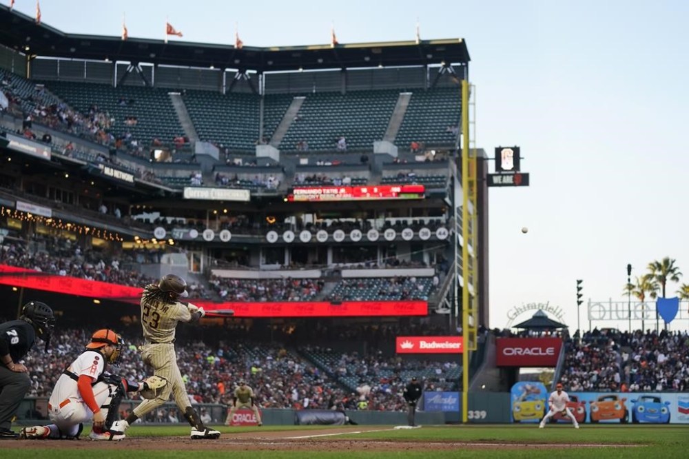San Diego Padres' Fernando Tatis Jr. (23) hits a home run in front of San Francisco Giants catcher Patrick Bailey during the fifth inning of a baseball game in San Francisco, Tuesday, June 20, 2023. (AP Photo/Jeff Chiu)