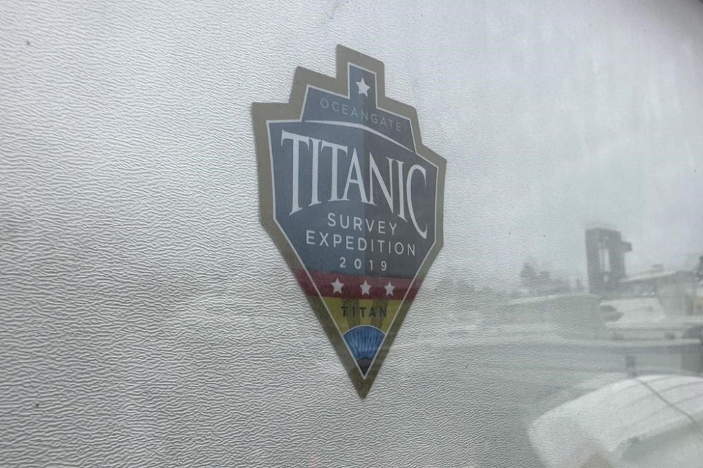 The logo for an OceanGate Expeditions 2019 Titanic expedition is seen on a marine industrial warehouse office door in Everett, Wash., Tuesday, June 20, 2023. Rescuers are racing against time to find the missing submersible carrying five people, who were reported overdue Sunday night. (AP Photo/Ed Komenda)
