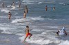 FILE - People cool off on Puerto de Sagunto beach in Spain, Tuesday, Aug. 16, 2022. (AP Photo/Alberto Saiz, File)