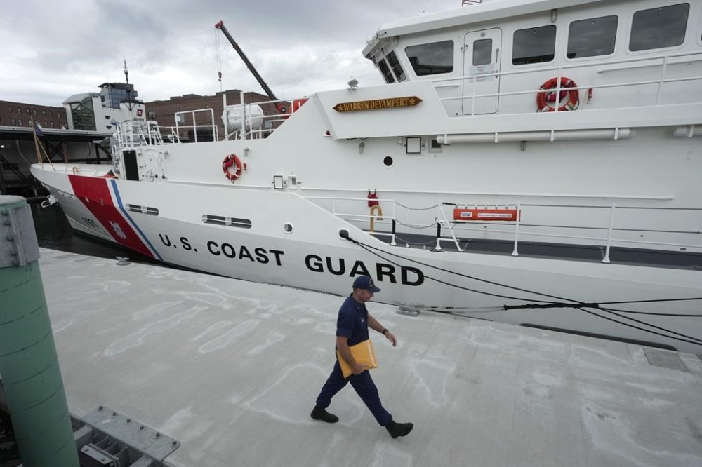 FILE - The U.S. Coast Guard Cutter Warren Deyampert is docked as a member of the Coast Guard walks past, Tuesday, June 20, 2023, at Coast Guard Base Boston, in Boston. . (AP Photo/Steven Senne, File)