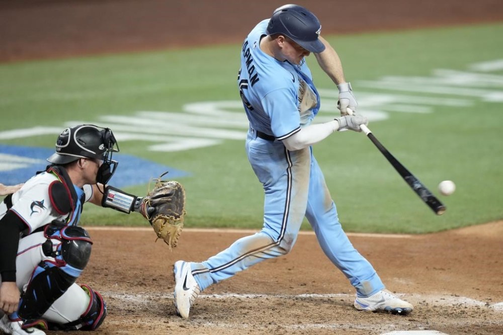 Toronto Blue Jays' Matt Chapman hits a solo home run during the eighth inning of a baseball game against the Miami Marlins, Wednesday, June 21, 2023, in Miami. At left is Miami Marlins catcher Jacob Stallings. (AP Photo/Lynne Sladky)