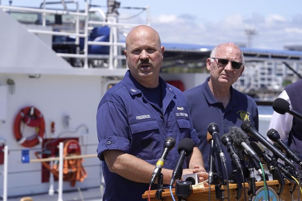 U.S. Coast Guard Capt. Jamie Frederick, left, faces reporters as Paul Hankins, U.S. Navy civilian contractor supervisor of salvage, right, looks on during a news conference, Wednesday, June 21, 2023, at Coast Guard Base Boston, in Boston. The U.S. Coast Guard says sounds and banging noises have been heard from the search area for Titanic submersible. (AP Photo/Steven Senne)