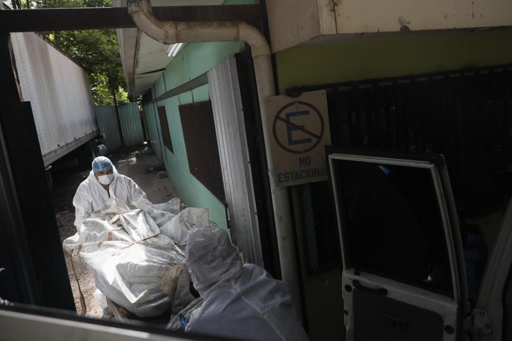 Forensic experts unload a body removed from a women's prison, at the medical morgue in Tegucigalpa, Honduras, Wednesday, June 21, 2023. A riot on Tuesday at the prison northwest of the Honduran capital left at least 46 female inmates dead, many of them burned, shot or stabbed to death, a Honduran police official said. (AP Photo/Elmer Martinez)