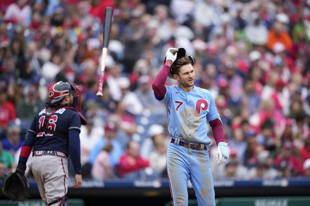 Philadelphia Phillies' Trea Turner, right, reacts after striking out against Atlanta Braves pitcher A.J. Minter during the eighth inning of a baseball game, Thursday, June 22, 2023, in Philadelphia. (AP Photo/Matt Slocum)