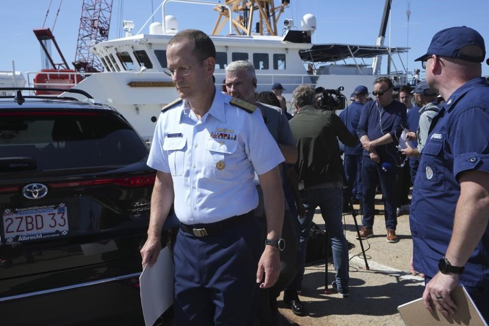 U.S. Coast Guard Rear Adm. John Mauger, commander of the First Coast Guard District, left, steps away from the media at the conclusion of a news conference, Thursday, June 22, 2023, at Coast Guard Base Boston in Boston. The missing submersible Titan imploded near the wreckage of the Titanic, killing all five people on board, according to the U.S. Coast Guard. (AP Photo/Steven Senne)