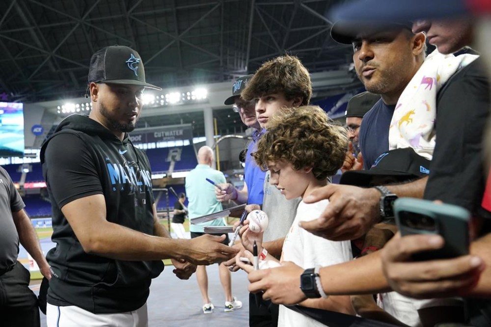 Miami Marlins second baseman Luis Arraez signs autographs before a baseball game against the Toronto Blue Jays, Tuesday, June 20, 2023, in Miami. (AP Photo/Lynne Sladky)