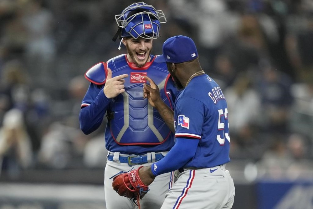 Texas Rangers right fielder Adolis Garcia, right, celebrates with catcher Jonah Heim, left, after closing the 10th inning of a baseball game against the New York Yankees, Friday, June 23, 2023, in New York. (AP Photo/John Minchillo)
