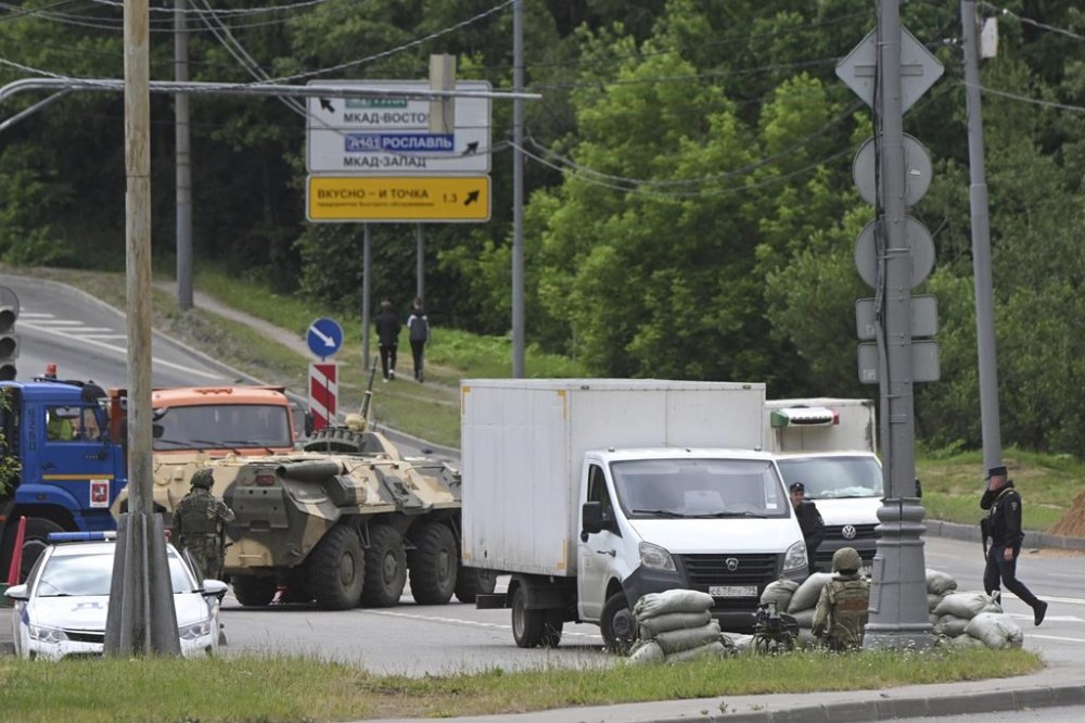 Russian army servicemen, and police officers guard the highway at the entrance to Moscow, Russia, Saturday, June 24, 2023. (AP Photo)