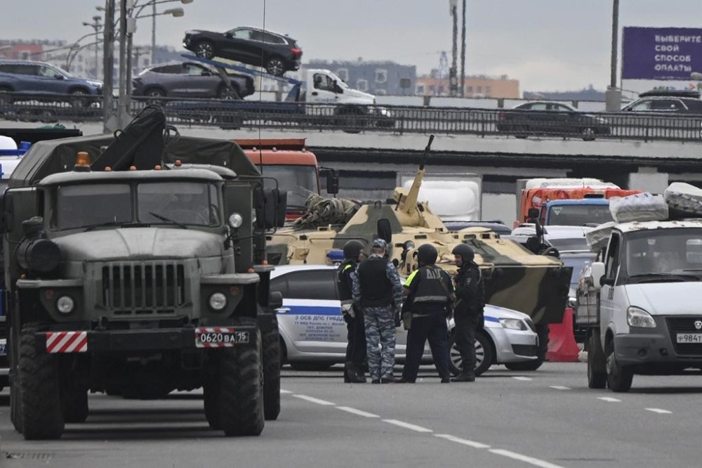 An APC and police officers stand on the highway on the outskirts of Moscow, Russia, Saturday, June 24, 2023. (AP Photo)
