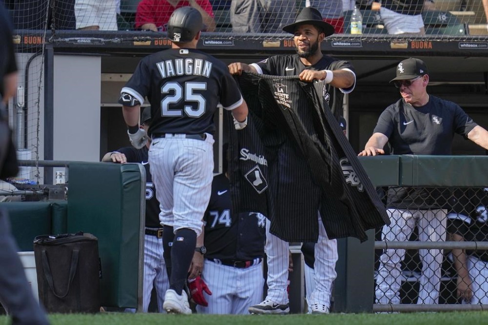Chicago White Sox's Elvis Andrus, center right, brings the team's cape and fedora out for Andrew Vaughn (25) after Vaughn hit a home run during the sixth inning of a baseball game against the Boston Red Sox, Saturday, June 24, 2023, in Chicago. (AP Photo/Erin Hooley)