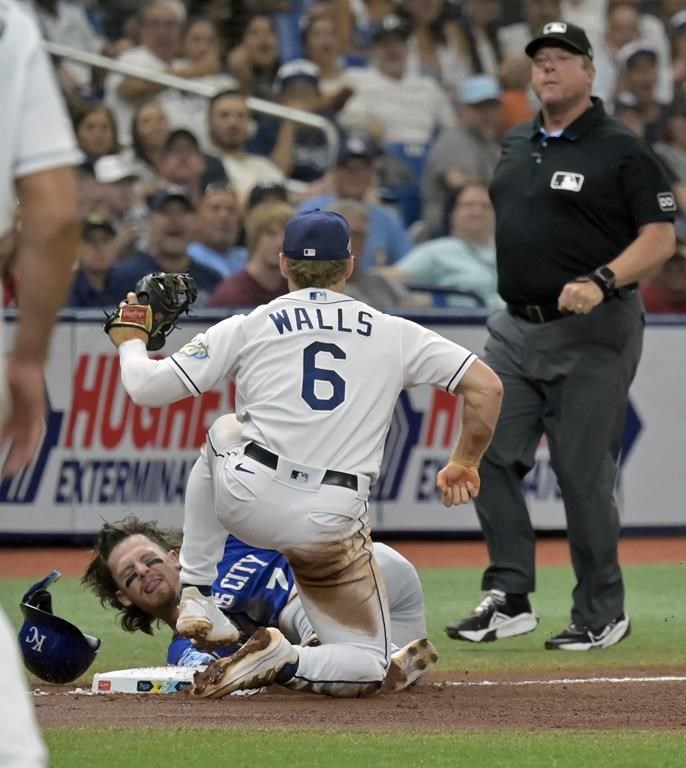 Umpire Bruce Dreckman, right, looks on after Tampa Bay Rays' Taylor Walls tagged out Kansas City Royals' Bobby Witt Jr. at third base during the fourth inning of a baseball game Saturday, June 24, 2023, in St. Petersburg, Fla. (AP Photo/Steve Nesius)