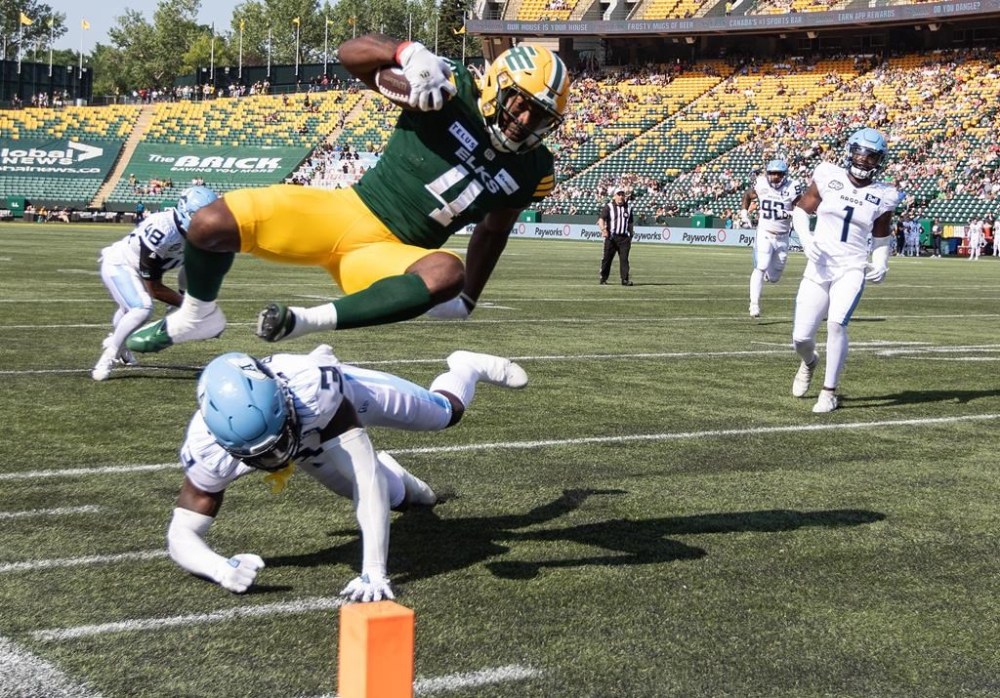 Toronto Argonauts Jamal Peters (3) misses the tackle as Edmonton Elks Kevin Brown (4) dives in for the touchdown during first half CFL action in Edmonton, Alta., on Sunday June 25, 2023. THE CANADIAN PRESS/Jason Franson.