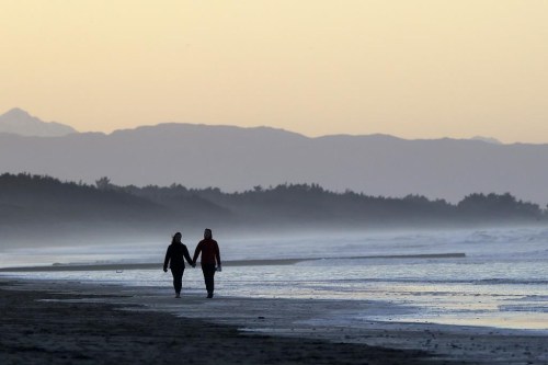 FILE - A couple walk along New Brighton Beach at sunset in Christchurch, New Zealand, Tuesday, June 9, 2020. Contrary to popular belief, estate planning isn’t just for older adults or the wealthy, as unexpected circumstances can affect anyone regardless of age or financial status. (AP Photo/Mark Baker, File)