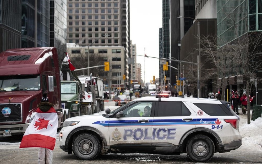 An Ottawa police vehicle blocks off Kent Street in front of parked trucks as a protest against COVID-19 restrictions continues into its second week, in Ottawa on Sunday, Feb. 6, 2022. THE CANADIAN PRESS FILES/Justin Tang