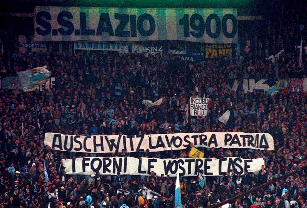 FILE - Lazio fans display banners from the stands reading
