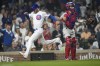 Chicago Cubs' Cody Bellinger scores behind Philadelphia Phillies catcher Garrett Stubbs during the eighth inning of a baseball game Tuesday, June 27, 2023, in Chicago. (AP Photo/Charles Rex Arbogast)