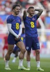 England's Jack Grealish, left and England's James Maddison talk during the warm up before the Euro 2024 group C qualifying soccer match between England and North Macedonia at Old Trafford in Manchester, Monday June 19, 2023. (AP Photo/Dave Thompson)