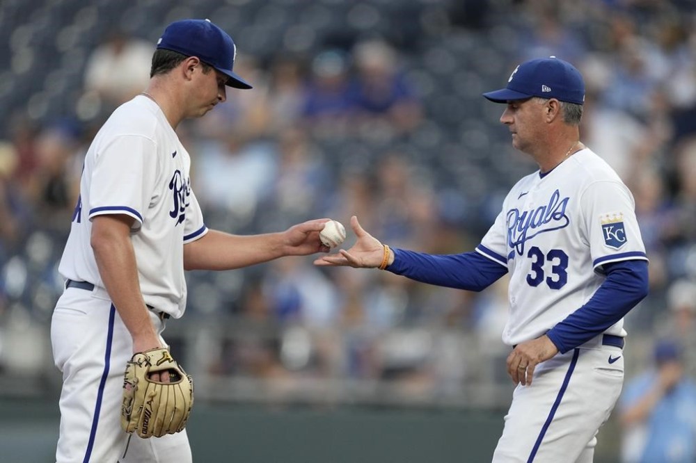 Kansas City Royals manager Matt Quatraro (33) takes the ball from starting pitcher Austin Cox after making a pitching change during the fourth inning of a baseball game against the Cleveland Guardians Wednesday, June 28, 2023, in Kansas City, Mo. (AP Photo/Charlie Riedel)