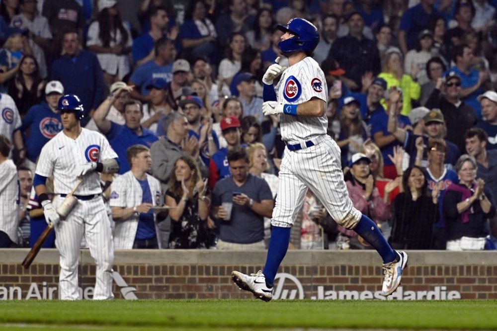 Chicago Cubs' Dansby Swanson points after he hits a home run against the Philadelphia Phillies during the fourth inning of a baseball game, Wednesday, June 28, 2023, in Chicago. (AP Photo/Matt Marton)