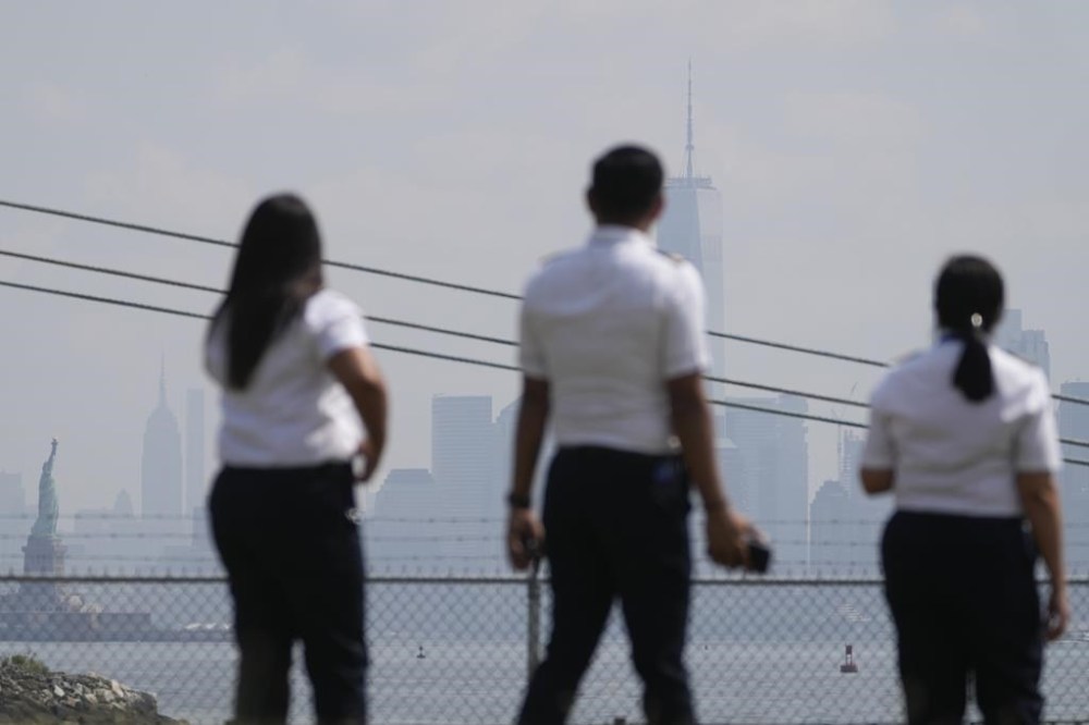 People look at the Statue of Liberty and the hazy New York City skyline from Bayonne, N.J., Thursday, June 29, 2023. Forecasters say the only break much of America can hope for anytime soon from eye-watering dangerous smoke from fire-struck Canada is brief bouts of shirt-soaking sweltering heat and humidity from a southern heat wave that has already proven deadly. (AP Photo/Seth Wenig)