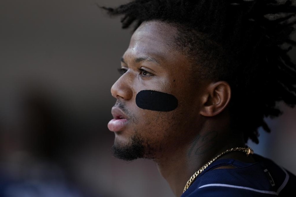 Atlanta Braves' Ronald Acuna Jr. sits in the dugout during the third inning of a baseball game against the Cincinnati Reds, Sunday, June 25, 2023, in Cincinnati. (AP Photo/Jeff Dean)