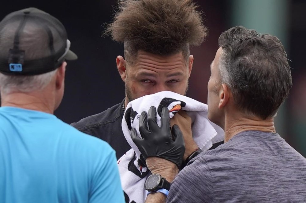 Miami Marlins' Yuli Gurriel, center, is assisted after being hit in the face by a baseball before a baseball game against the Boston Red Sox, Thursday, June 29, 2023, in Boston. (AP Photo/Steven Senne)