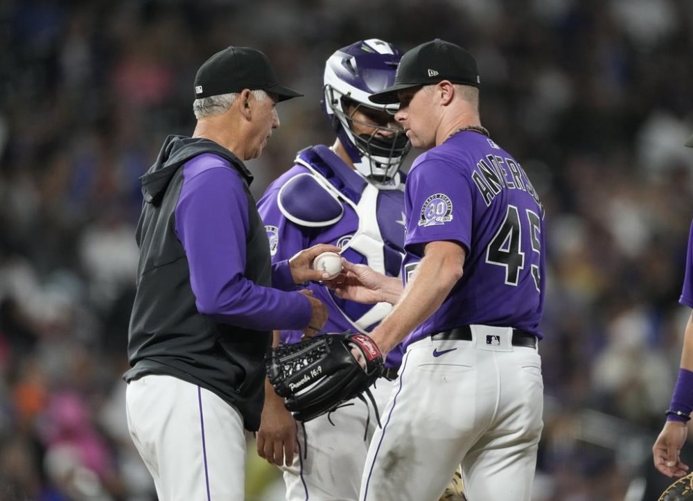 Colorado Rockies manager Bud Black, left, takes the ball from starting pitcher Chase Anderson, while catcher Elias Diaz looks on during the fourth inning of the team's baseball game against the Los Angeles Dodgers on Thursday, June 29, 2023, in Denver. (AP Photo/David Zalubowski)