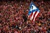 FILE - Atletico de Madrid supporters wave a flag with their team emblem as they celebrate the Spanish first division title ''La Liga'' with his team players at the Neptuno fountain in Madrid, Sunday, May 18, 2014. Atletico Madrid will go back to its old emblem after listening to its fans. Atletico said Friday, May 2023, the majority of its members voted to revert to the old badge that had been replaced amid controversy in 2017. (AP Photo/Daniel Ochoa de Olza, File)