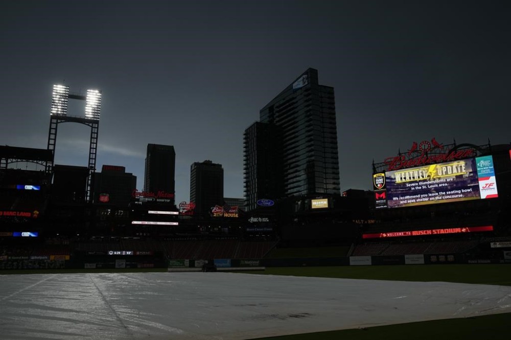 The skies darken and tarp covers the field as rain threatens the scheduled start of a baseball game between the St. Louis Cardinals and the New York Yankees Friday, June 30, 2023, in St. Louis. (AP Photo/Jeff Roberson)