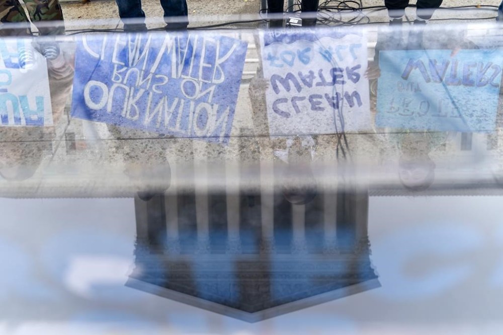 FILE - Supporters of the Clean Water Act demonstrate outside the Supreme Court, Monday, Oct. 3, 2022, in Washington, as the court begins arguments in Sackett v. Environmental Protection Agency (EPA). The court, by a 5-4 vote, also sharply limited the federal government's authority to police water pollution into certain wetlands, although all nine justices rejected the administration's position. (AP Photo/Jacquelyn Martin, File)