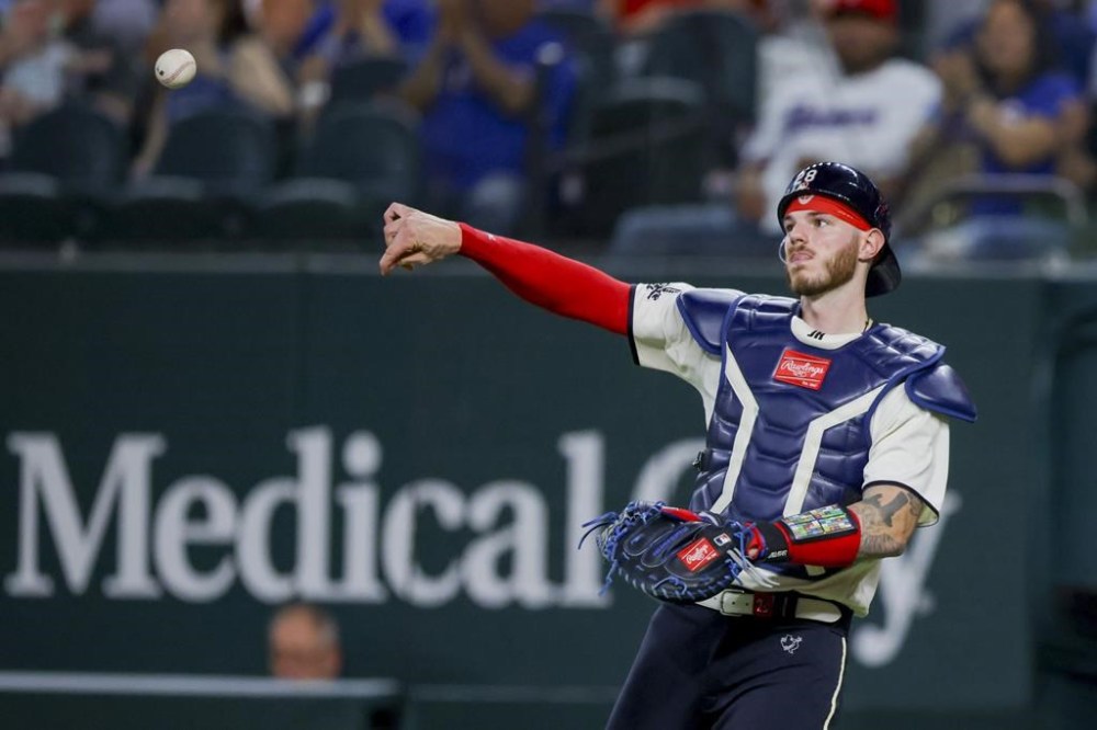 Texas Rangers' Jonah Heim throws after catching a fly ball in the sixth inning of a baseball game against the Houston Astros, Saturday, July 1, 2023, in Arlington, Texas. (AP Photo/Gareth Patterson)