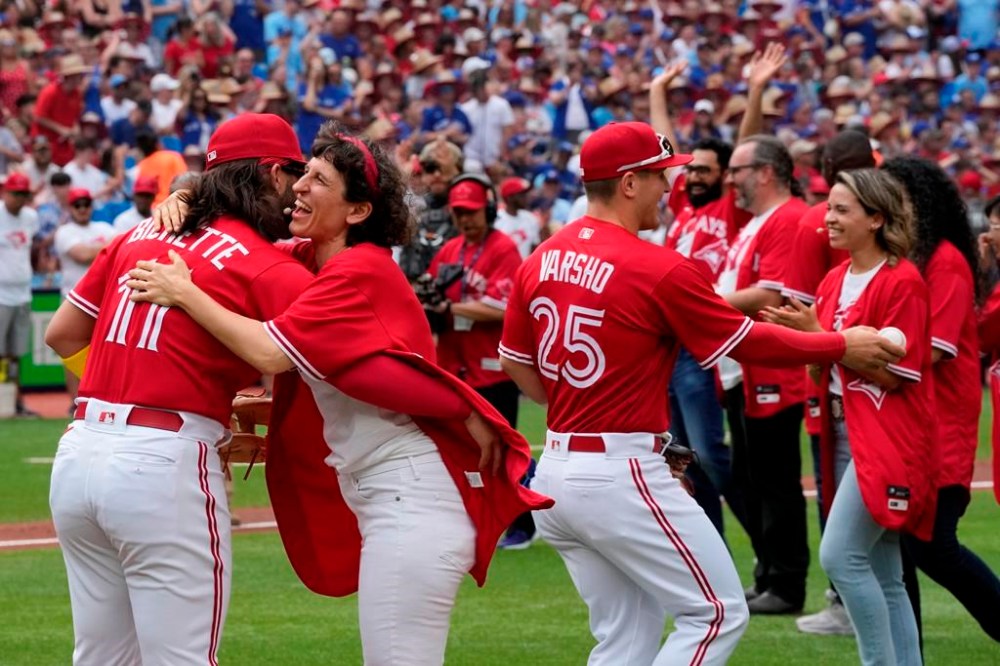 People who took part in a Canada Day citizenship ceremony and the ceremonial first pitch greet the Blue Jays players before the start of MLB AL baseball action against the Boston Red Sox in Toronto on Saturday, July 1, 2023. THE CANADIAN PRESS/Frank Gunn