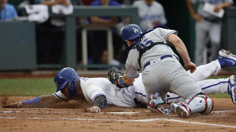 Kansas City Royals' Salvador Perez, left, beats a tag by Los Angeles Dodgers catcher Will Smith, right, to score off a Samad Taylor sacrifice fly during the first inning of a baseball game in Kansas City, Mo., Saturday, July 1, 2023. (AP Photo/Colin E. Braley)