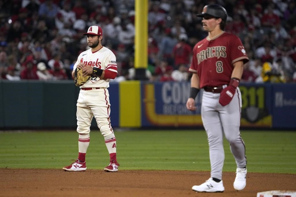 Los Angeles Angels shortstop David Fletcher, left, looks over at his brother Arizona Diamondbacks' Dominic Fletcher as Dominic stands on second during the fifth inning of a baseball game Saturday, July 1, 2023, in Anaheim, Calif. (AP Photo/Mark J. Terrill)