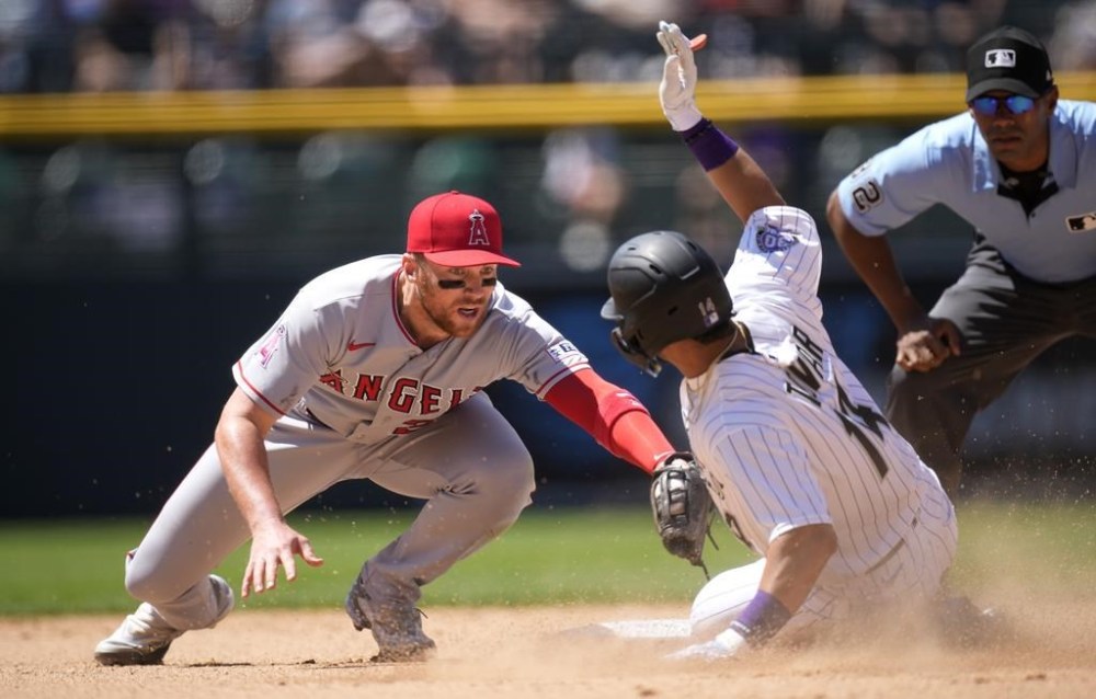 Los Angeles Angels second baseman Brandon Drury, left, tags out Colorado Rockies' Ezequiel Tovar as he tries to steal second base in the seventh inning of a baseball game, Sunday, June 25, 2023, in Denver. (AP Photo/David Zalubowski)