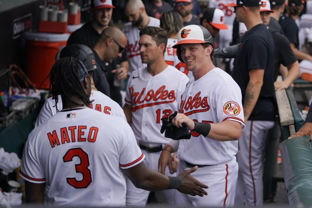 Baltimore Orioles' Adley Rutschman, right, talks with Jorge Mateo (3) in the dugout after scoring on a single by Aaron Hicks in the eighth inning of a baseball game against the Minnesota Twins, Sunday, July 2, 2023, in Baltimore. The Orioles won 2-1. (AP Photo/Julio Cortez)