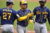 Milwaukee Brewers' William Contreras, center, is greeted by Willy Adames (27) and Raimel Tapia after hitting a three-run home run off Pittsburgh Pirates starting pitcher Rich Hill during the third inning of a baseball game in Pittsburgh, Sunday, July 2, 2023. (AP Photo/Gene J. Puskar)