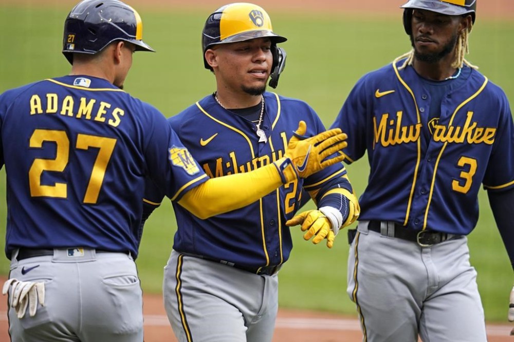 Milwaukee Brewers' William Contreras, center, is greeted by Willy Adames (27) and Raimel Tapia after hitting a three-run home run off Pittsburgh Pirates starting pitcher Rich Hill during the third inning of a baseball game in Pittsburgh, Sunday, July 2, 2023. (AP Photo/Gene J. Puskar)