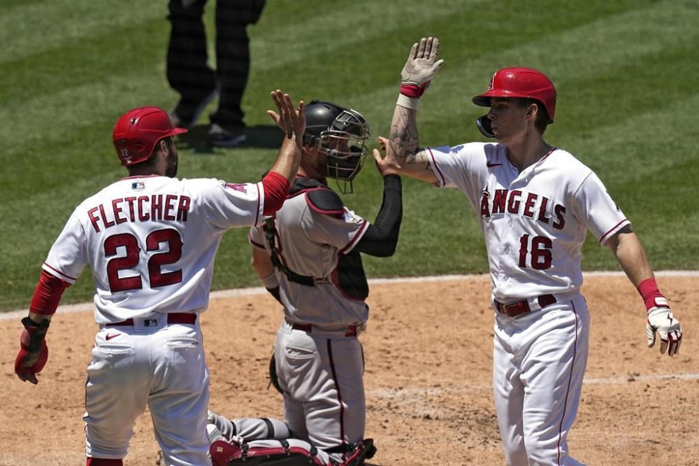Los Angeles Angels' Mickey Moniak, right, is congratulated by David Fletcher, left, after hitting a three-run home run as Arizona Diamondbacks catcher Carson Kelly kneels at the plate during the second inning of a baseball game Sunday, July 2, 2023, in Anaheim, Calif. (AP Photo/Mark J. Terrill)