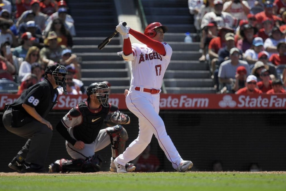 Los Angeles Angels' Shohei Ohtani, right, hits a solo home run as Arizona Diamondbacks catcher Gabriel Moreno, center, and home plate umpire Doug Eddings watch during the eighth inning of a baseball game Sunday, July 2, 2023, in Anaheim, Calif. (AP Photo/Mark J. Terrill)