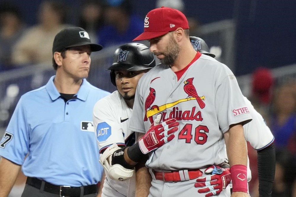 Miami Marlins' Luis Arraez, center, hugs St. Louis Cardinals first baseman Paul Goldschmidt (46) after hitting a single during the first inning of a baseball game, Monday, July 3, 2023, in Miami. (AP Photo/Lynne Sladky)