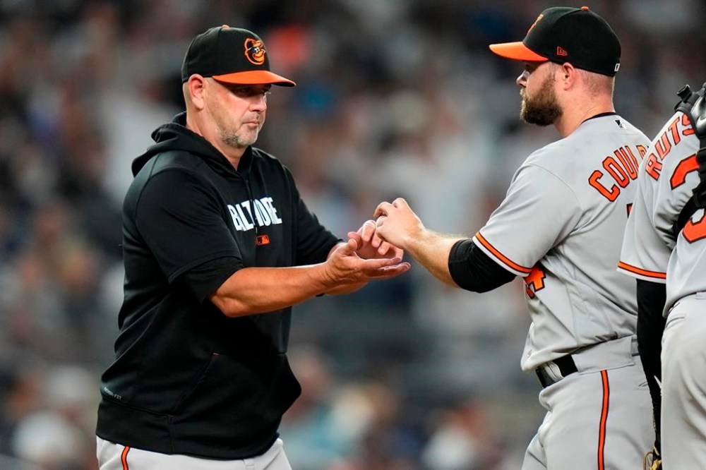 Baltimore Orioles manager Brandon Hyde, left, takes the ball from relief pitcher Danny Coulombe during the eighth inning of a baseball game against the New York Yankees, Monday, July 3, 2023, in New York. (AP Photo/Frank Franklin II)