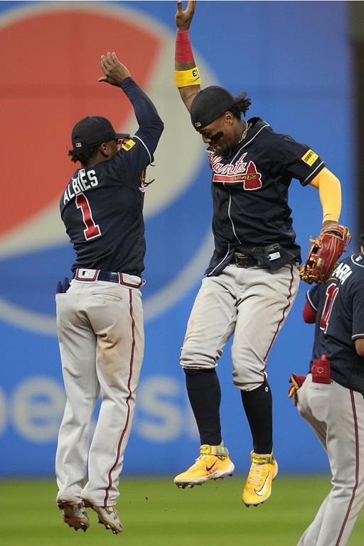 Atlanta Braves' Ozzie Albies (1) and Ronald Acuna Jr., right, celebrate after they defeated the Cleveland Guardians in a baseball game Monday, July 3, 2023, in Cleveland. (AP Photo/Sue Ogrocki)