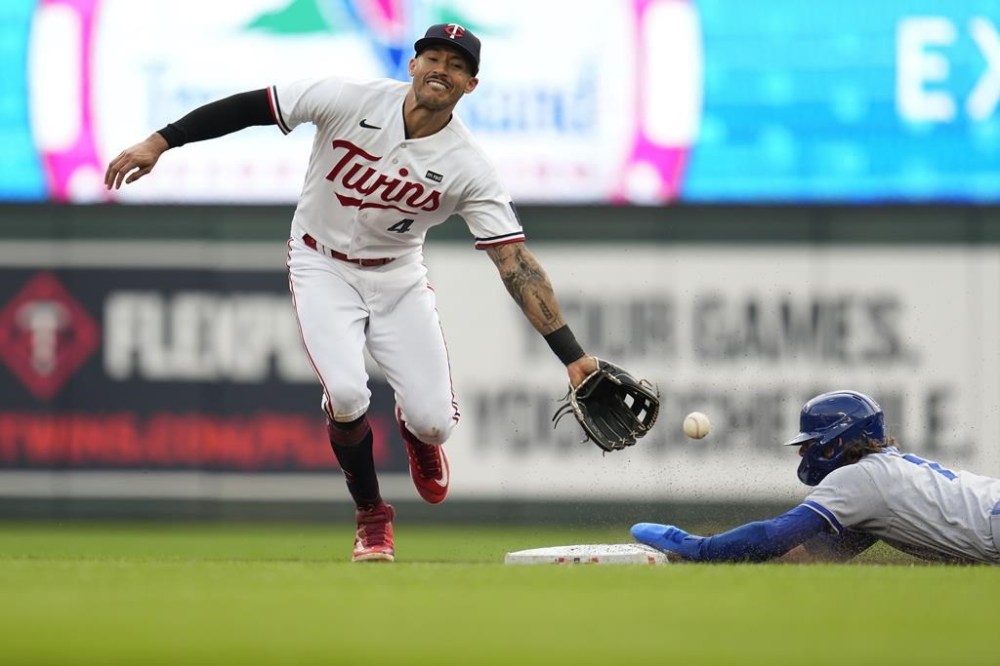 Kansas City Royals' Bobby Witt Jr., right, beats a throw to Minnesota Twins shortstop Carlos Correa, left, to steal second base during the third inning of a baseball game Monday, July 3, 2023, in Minneapolis. (AP Photo/Abbie Parr)