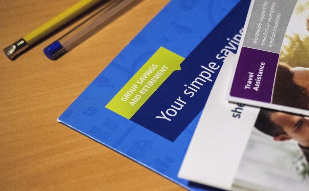 Samples of various employee benefits brochures are shown in a photo illustration, in Toronto on Tuesday, July 17, 2018. Mercer says Canadian defined benefit pension plans continued to improve in the second quarter of 2023.THE CANADIAN PRESS/Giordano Ciampini