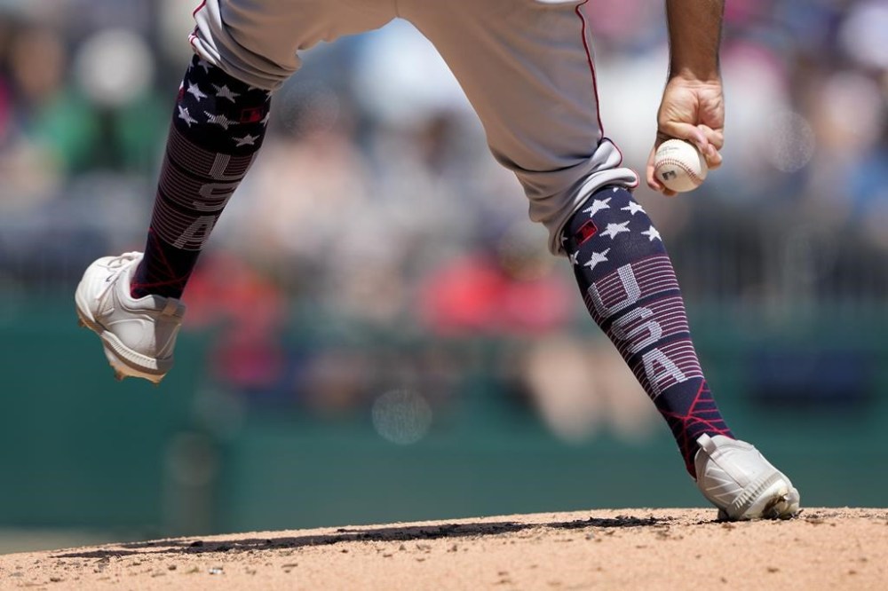Cincinnati Reds starting pitcher Brett Kennedy wears patriotic socks as he throws to the Washington Nationals in the second inning of a baseball game, Tuesday, July 4, 2023, in Washington. (AP Photo/Patrick Semansky)