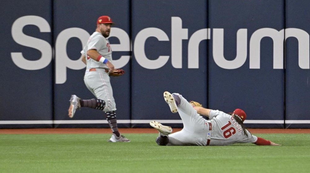 Philadelphia Phillies left fielder Kyle Schwarber watches as center fielder Brandon Marsh (16) makes a sliding catch on a fly ball hit by Tampa Bay Rays' Christian Bethancourt during the fifth inning of a baseball game Tuesday, July 4, 2023, in St. Petersburg, Fla. (AP Photo/Steve Nesius)