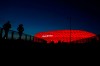 FILE - In this Monday, March 16, 2020 file photo jogger make their way after the sun sets at the 'Allianz Arena' soccer stadium, home of German first division, Bundesliga, team FC Bayern Munich in Munich, Germany. Bayern Munich is taking advantage of the summer break to lay a new hybrid-field for next season and modernize its stadium ahead of the 2024 European Championship and 2025 Champions League final. (AP Photo/Matthias Schrader, file)