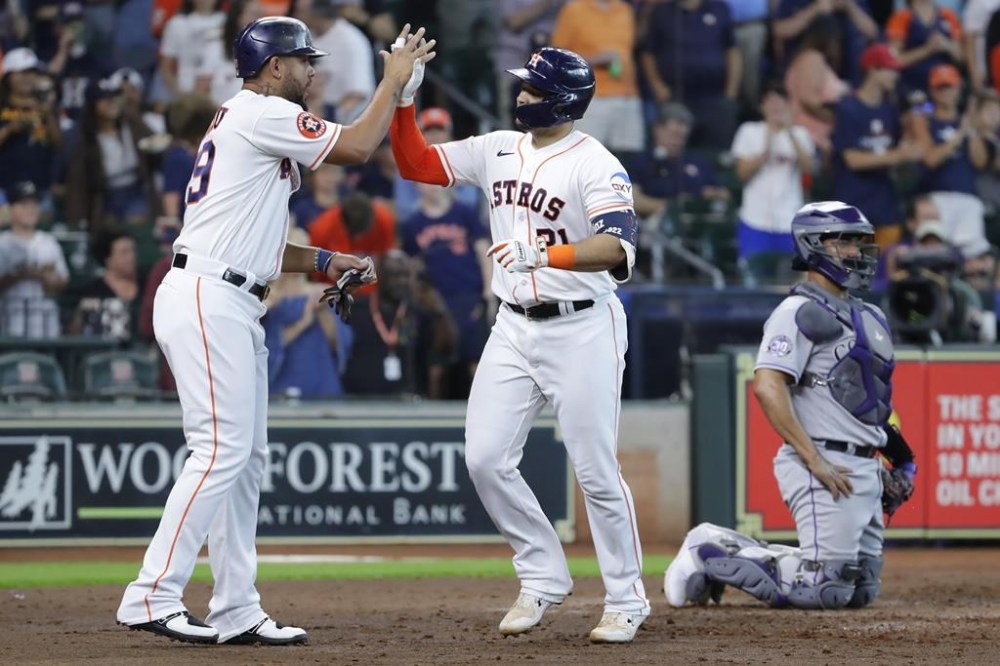 Houston Astros' Jose Abreu, left, and Yainer Diaz, center, celebrate at the plate behind Colorado Rockies catcher Elias Diaz, right, after a two run home run by Diaz during the fourth inning of a baseball game Wednesday, July 5, 2023, in Houston. (AP Photo/Michael Wyke)