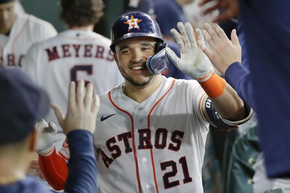Houston Astros' Yainer Diaz (21) collects high fives in the dugout after his solo home run against the Colorado Rockies during the second inning of a baseball game Wednesday, July 5, 2023, in Houston. (AP Photo/Michael Wyke)